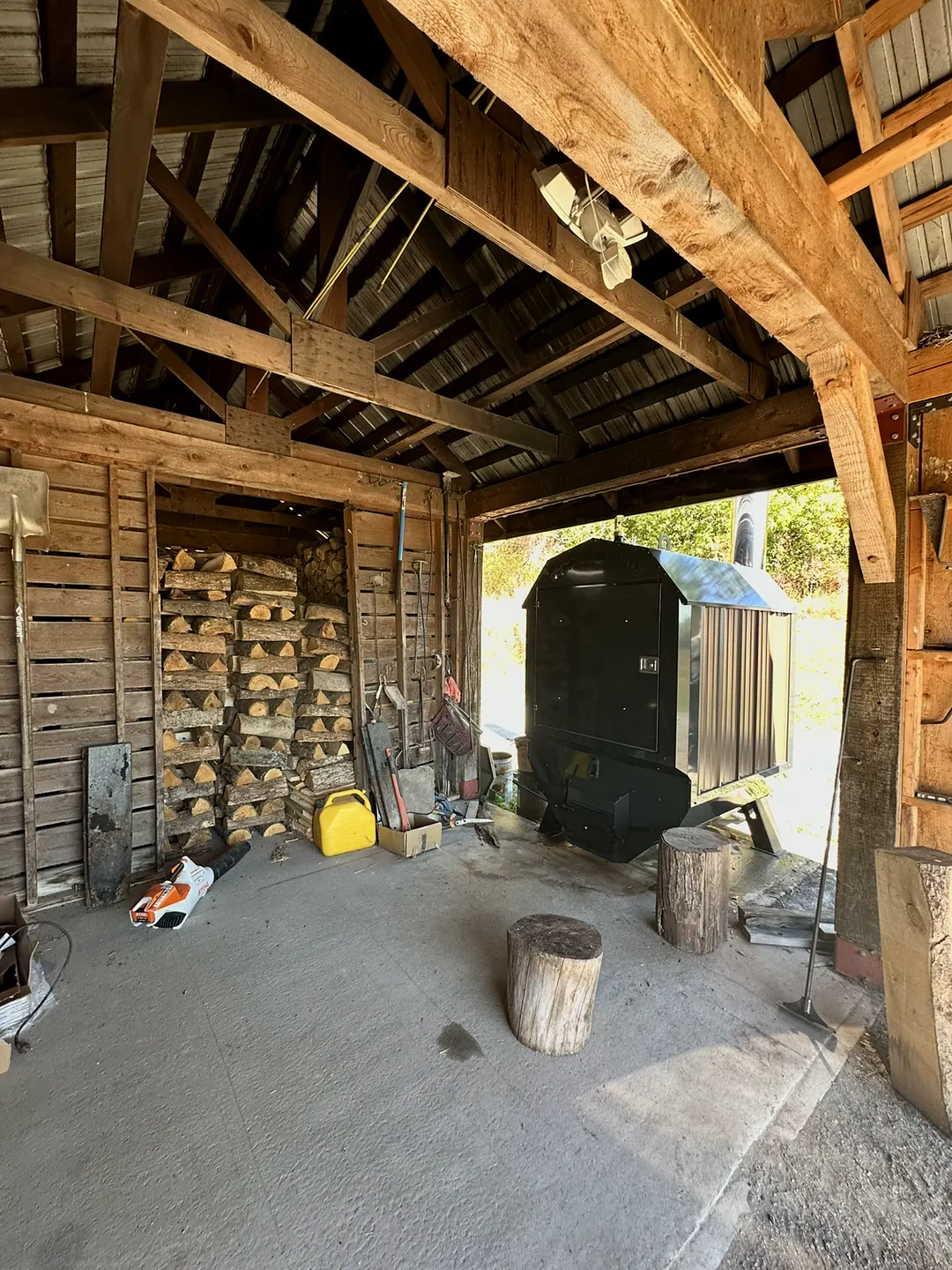 Under the woodshed, next to the firewood